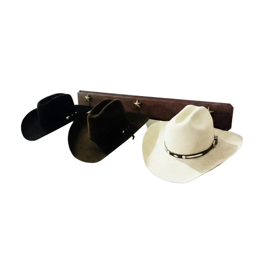 Wall-mounted hat rack with black cowboy hats and a white cowboy hat on a white background
